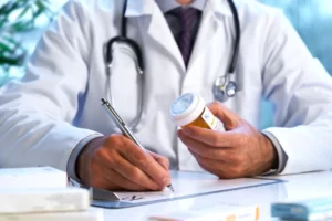 pain management specialist writing prescriptions to his patient