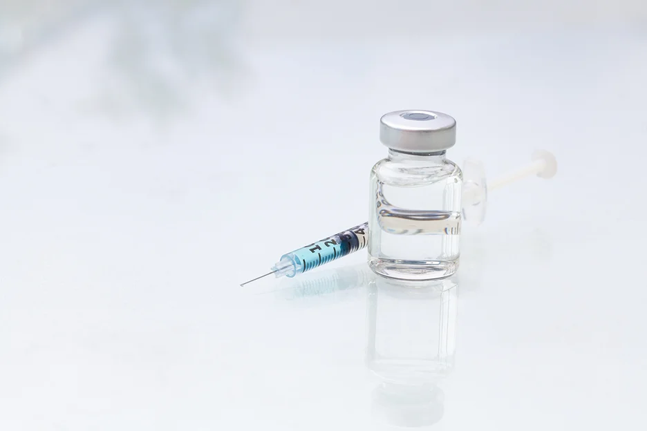 a syringe and a vial of lip filler