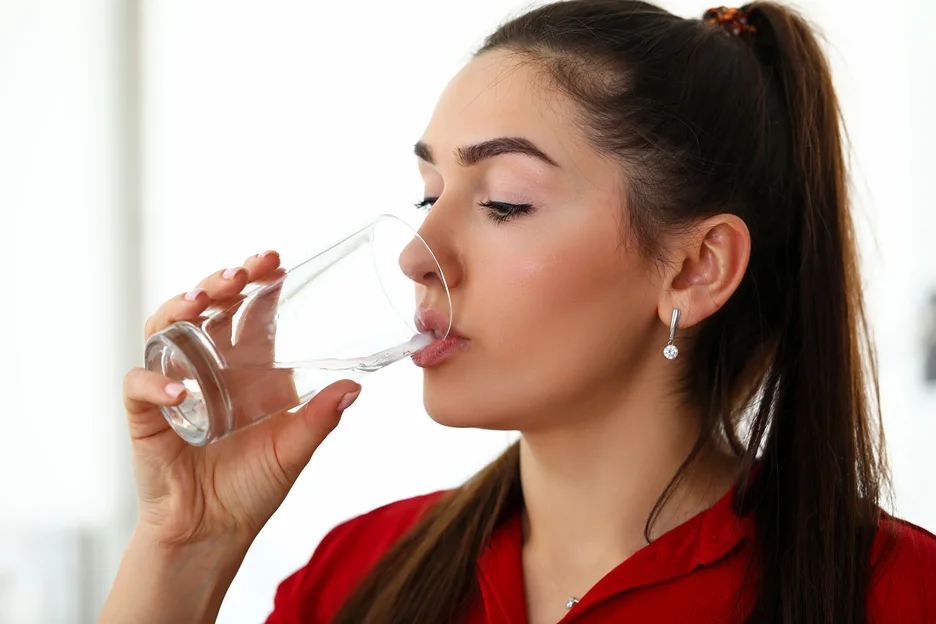 a woman drinks a glass of water