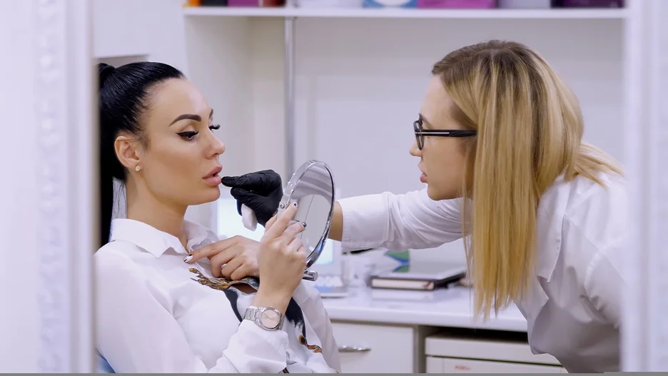 a lip filler injector checks the lips of her patient after lip filler procedure