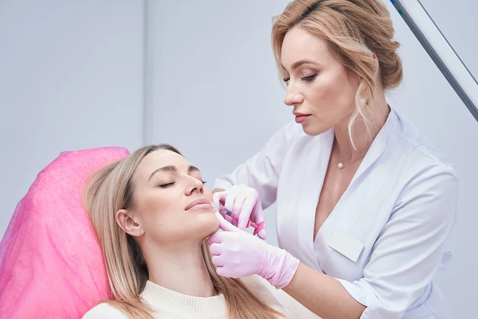 an injector injects lip fillers on her patient