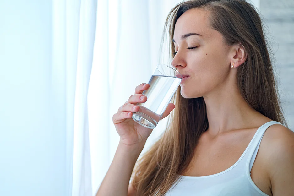 a woman drinks a glass of water